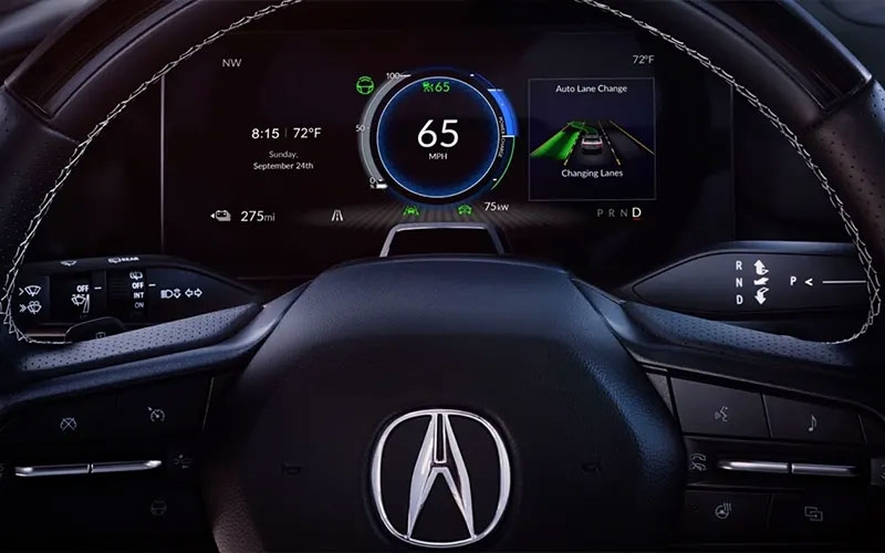 Close-up view of a 2025 Acura ZDX dashboard showing speed of 65 MPH, temperature, and auto lane change feature.